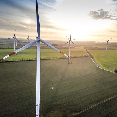 Windräder auf Wiese bei Sonnenaufgang